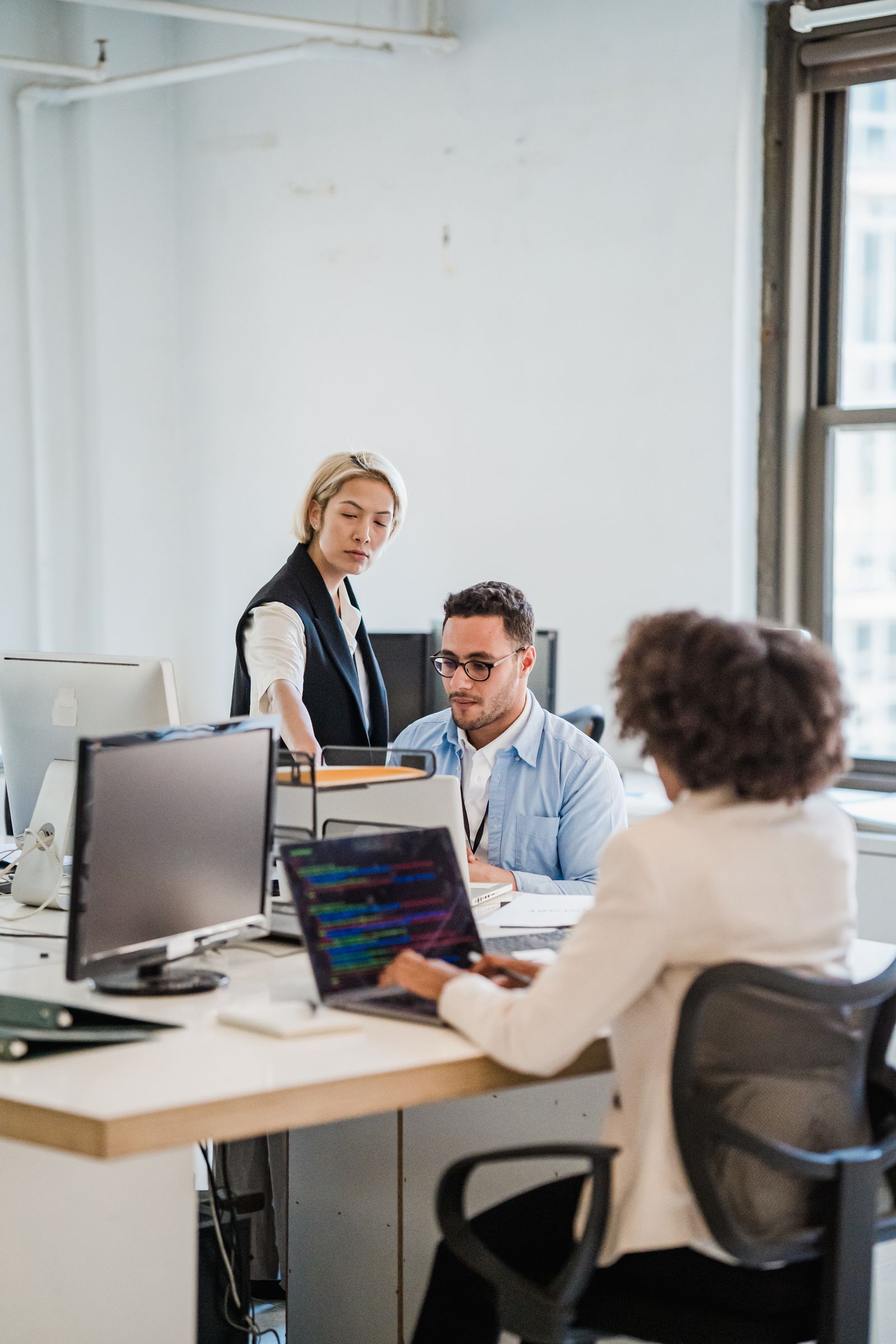 Business team collaborating around computers in a modern office