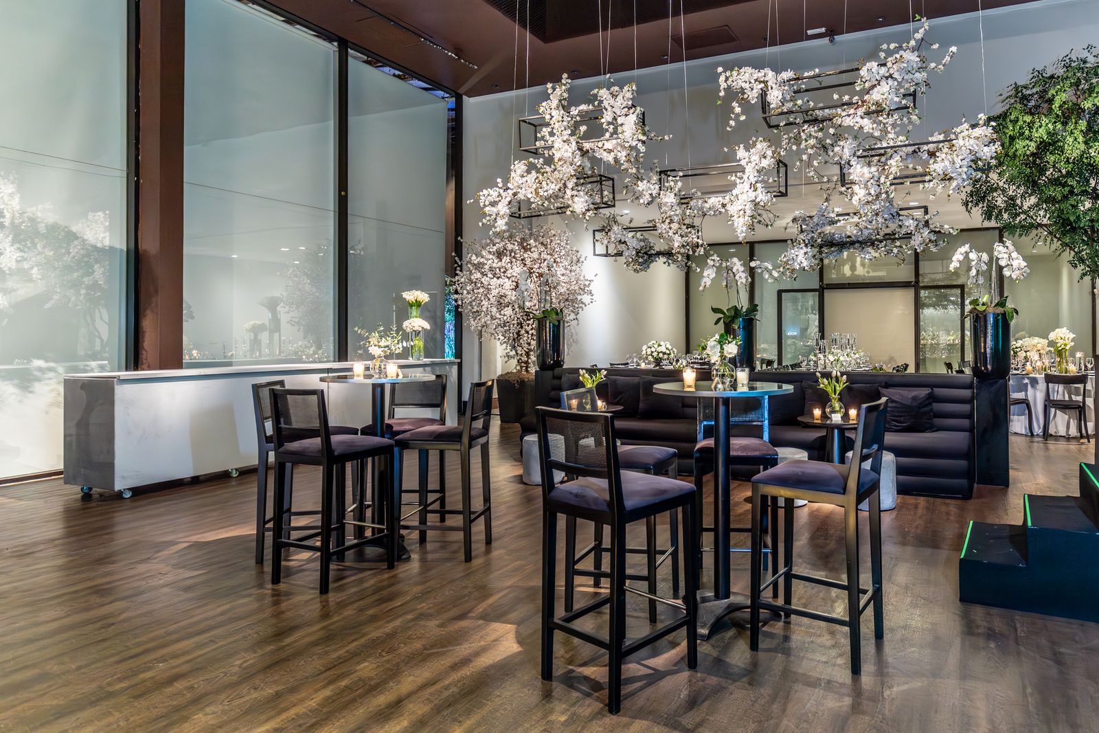 Event venue arranged with tables, chairs, flowers, and modern rental furniture