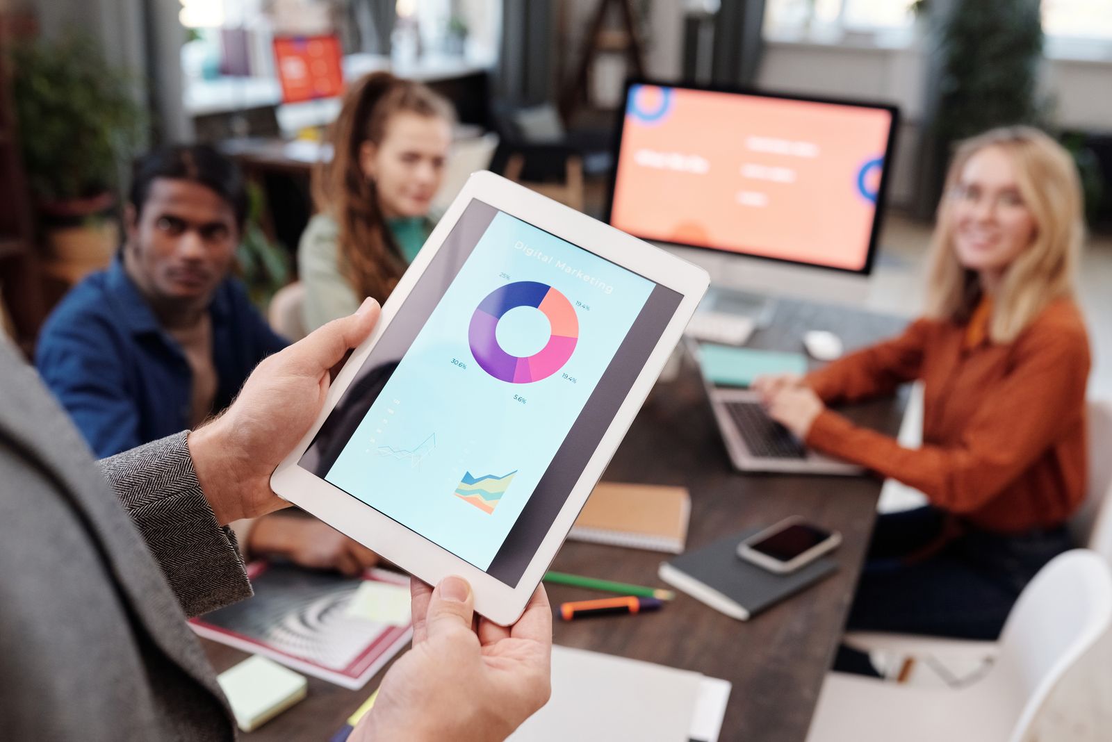 Business team reviewing digital marketing charts on a tablet