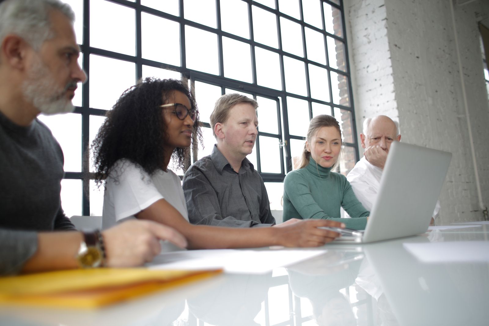 Software team reviewing work together on a laptop in a modern office